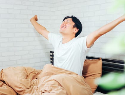 ベッドで起きる男性